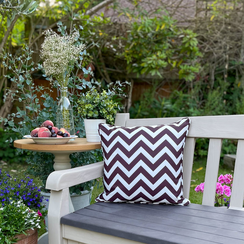 Brown & White Waterproof Outdoor Garden Cushion with a Striped Chevron Design on a Garden Bench with Flowers and Fruit
