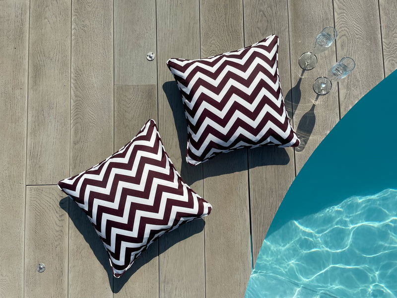 Two Brown & White Waterproof Outdoor Garden Cushions with a Striped Chevron Design Poolside